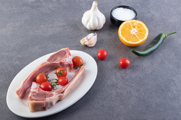 Viande non cuite avec tranches de citron et de poivre en grains.