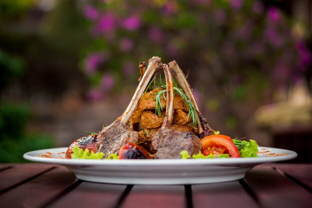 Viande sur l'os avec des légumes sur une plaque blanche. Restaurant.