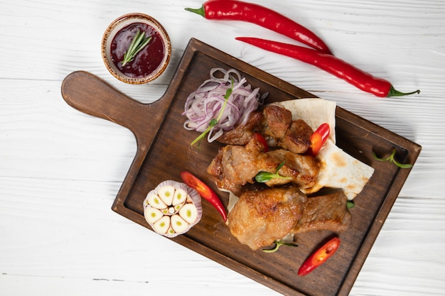 Viande sur pain pita à l'ail sur une table en bois