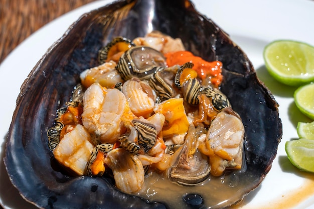 La viande de palourde crue dans un grand coquillage servi pour l'alimentation dans un restaurant local sur l'île de Zanzibar Tanzanie Afrique de l'Est