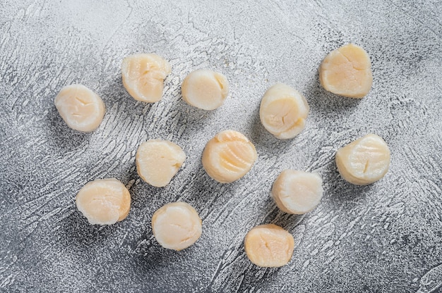 Viande de pétoncles crus sur une table de cuisine. Fond blanc. Vue de dessus.