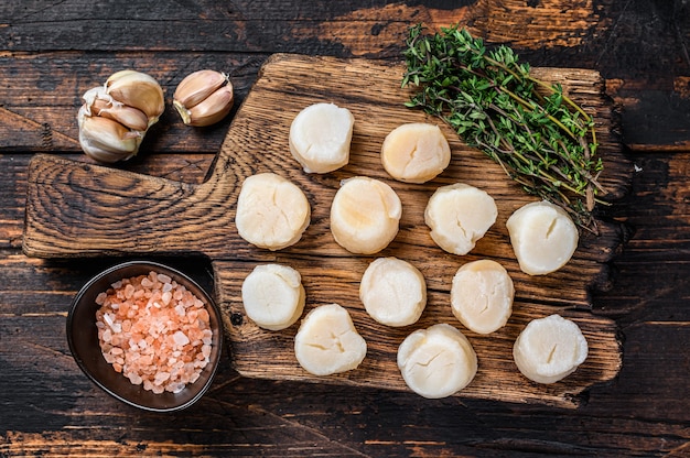 Viande de pétoncles à la vapeur sur une planche de bois.