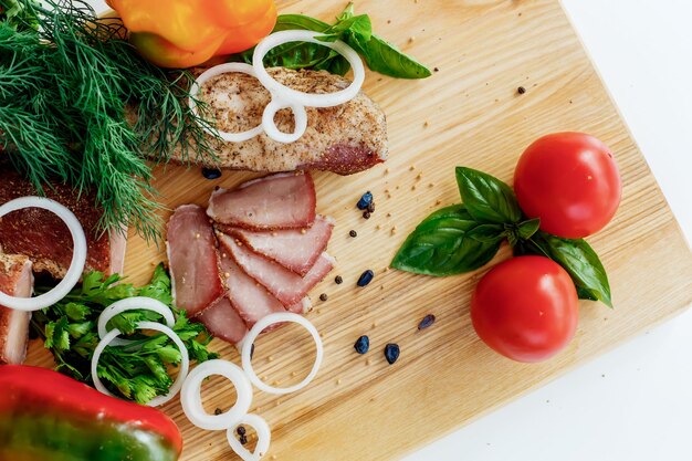 Viande sur une planche de bois avec des légumes