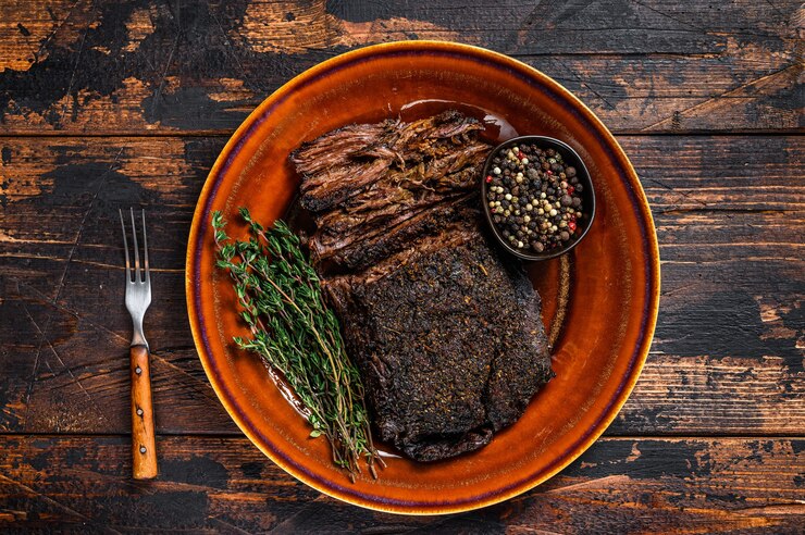 Photo viande de poitrine de bœuf wagyu fumée au barbecue. fond en bois sombre. vue de dessus.