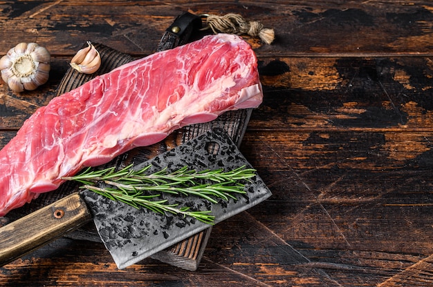 Viande de poitrine de veau crue sur côte de porc courte avec couteau de boucher