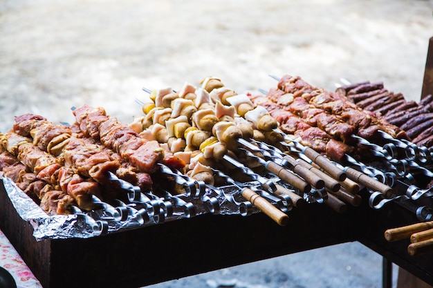 Viande et pommes de terre préparées pour la friture sur des brochettes.