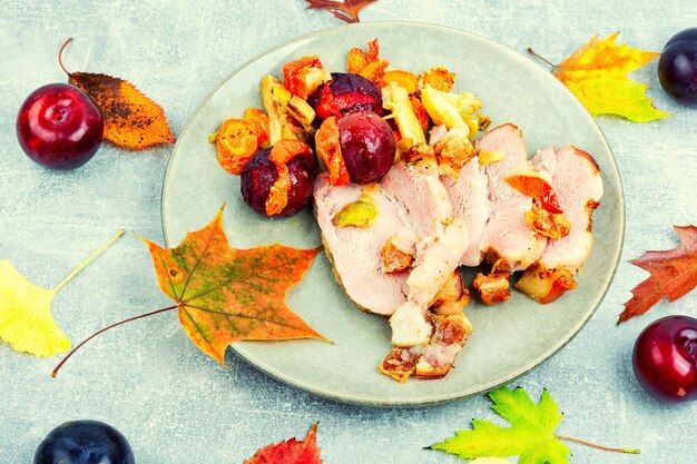 Viande de porc au four avec légumes et prunes