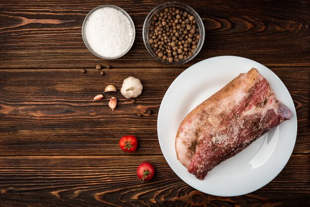 Viande de porc aux épices sur bois foncé.