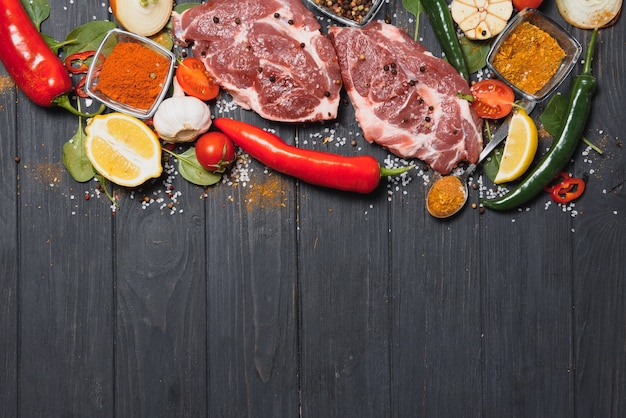 Viande de porc crue aux épices et légumes sur table en bois