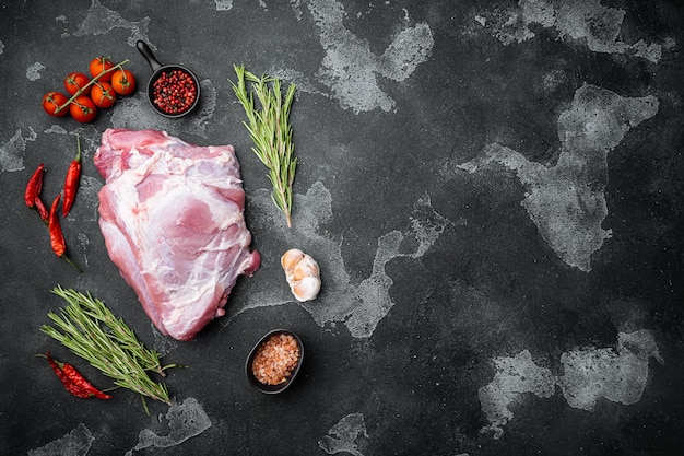 Viande de porc crue aux herbes sur fond de table en pierre noire vue de dessus à plat avec espace de copie pour le texte