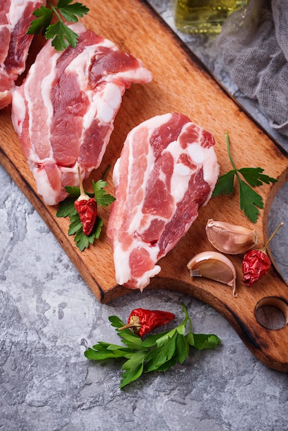 Viande de porc crue et ingrédients pour la cuisine. Mise au point sélective