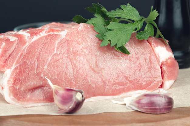 Viande de porc crue pour griller sur la coupe de cuisine avec assaisonnement et ail Morceaux de viande de rôti de boeuf cru avec des ingrédients pour la cuisson Viande de boeuf fraîche pour griller