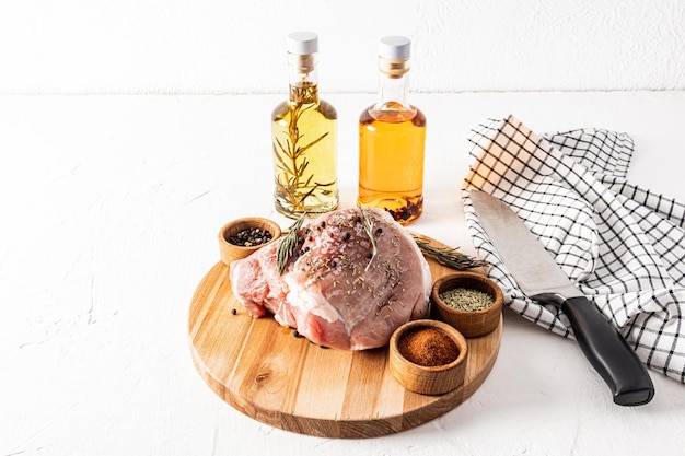 Viande de porc cuite à la vapeur juteuse sur une planche à découper en bois sur fond d'ingrédients pour la marinade et la cuisson