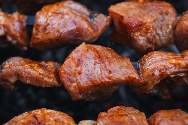 La viande de porc est cuite en brochettes sur un barbecue