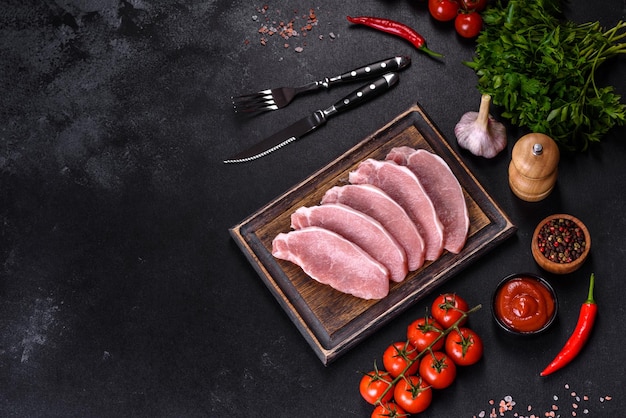 Viande de porc fraîche crue tranchée sur une planche à découper en bois