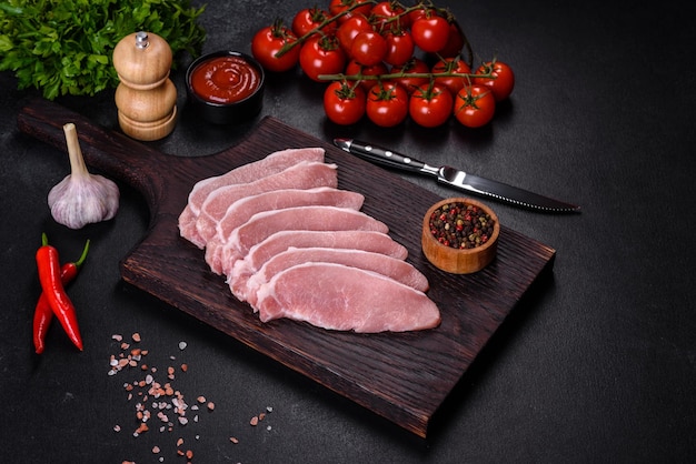 Viande de porc fraîche crue tranchée sur une planche à découper en bois