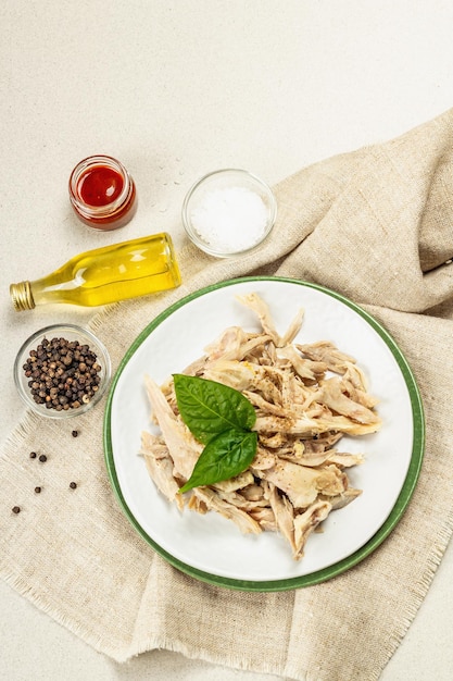 Viande de poulet bouillie avec des verts et des épices. Protéines animales faibles en gras, mode de vie alimentaire sain. Couverts, huile naturelle sur fond béton pierre, vue de dessus