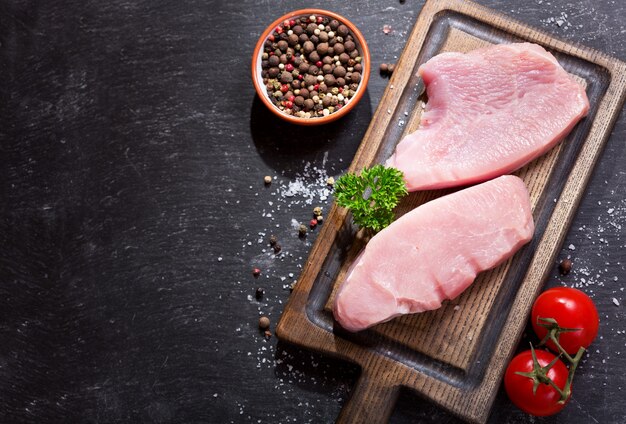 Viande de poulet fraîche sur planche de bois, vue du dessus