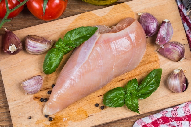 Viande de poulet frais sur planche de bois sur la table.