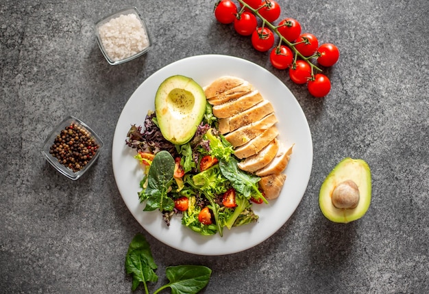 Viande de poulet grillée et salade de légumes frais de laitue tomate avocat et épinards