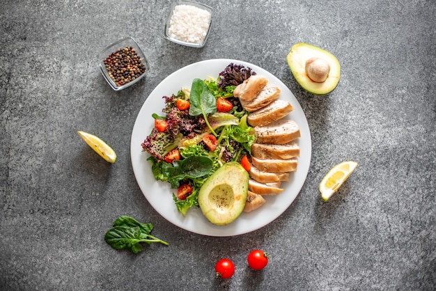 Viande de poulet grillée et salade de légumes frais de laitue tomate avocat et épinards