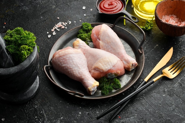 Viande de poulet Pilons de poulet frais crus sur fond de pierre d'ardoise noire Vue de dessus Viande crue