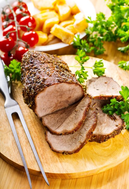 Viande rôtie aux légumes sur planche de bois