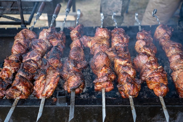 Viande rôtie cuite au barbecue Cuisson de kebab grillé sur une brochette en métal Tranches de côtelettes de viande de bœuf fraîche BBQ Plat oriental traditionnel shish kebab Grill sur charbon de bois et flamme street food Ukraine