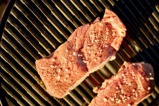 Viande rôtie sur le gril à gaz sur le gril du barbecue en plein air dans la viande de steak grillée à l'arrière-cour