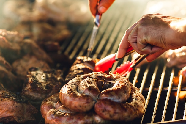 La viande et les saucisses sont frites sur un grand grill au café de la rue.