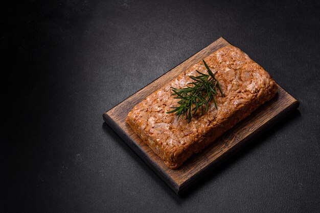 Viande savoureuse ou rouler sur une planche à découper en bois avec des épices et des herbes