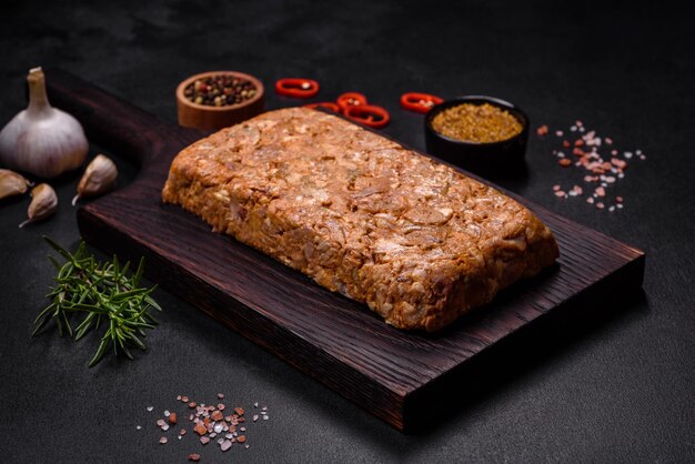 Viande savoureuse ou rouler sur une planche à découper en bois avec des épices et des herbes