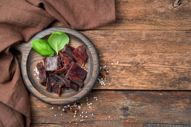 Viande séchée, basilic et épices sur fond de bois marron