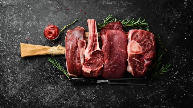 Viande Steaks de veau crus frais et viande Vue de dessus Vue de dessus à plat sur la table de coupe en pierre noire