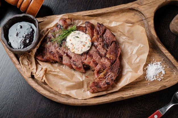 Viande tranchée sur une planche de bois avec des sauces