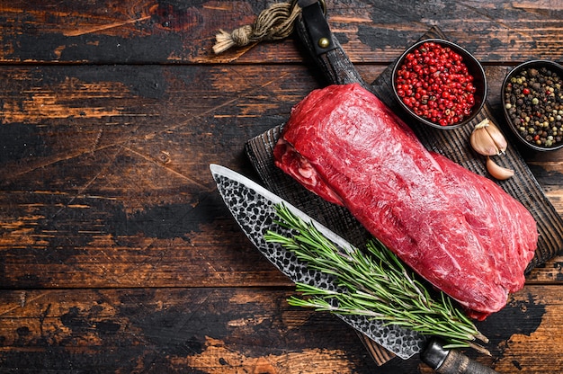 Viande de veau Filet entier cru pour steaks filet mignon sur une planche à découper en bois avec couteau de boucher