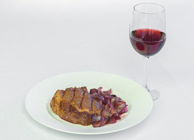 Photo viande de veau avec un verre de vin rouge