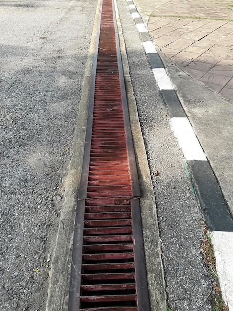 Vidange d'eau ou fossé sur la route Gouttières grille de vidange couverture de vidange La route draine la couverture d'égout grille en fer de vidange d'eau sur la route dans chaque ville L'eau descend dans le drain sur la route