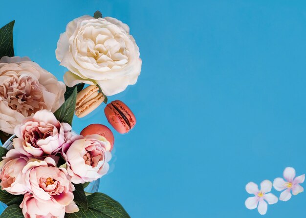 Vide avec des pivoines et des macarons sur fond bleu