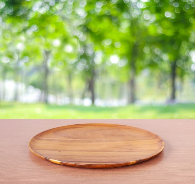 Vide plateau en bois rond sur la table sur fond de nature arbre flou