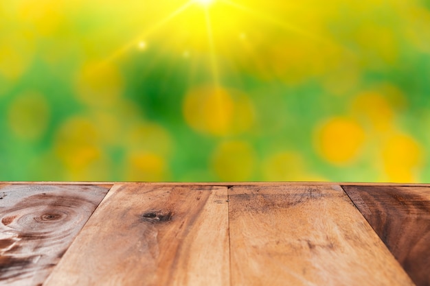 Vide vieille planche de bois sur le champ de fleurs nature flou pour montrer le produit.