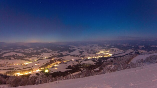 Vidéo en accéléré avec ciel bleu brouillard et neige d'un ciel étoilé au-dessus d'une station de ski enneigée dans les montagnes Vue aérienne panoramique des hautes montagnes Peaks Range Carpathian Mountain en Ukraine