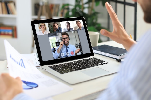 Vidéoconférence d'homme d'affaires avec un collègue sur un ordinateur portable au bureau.