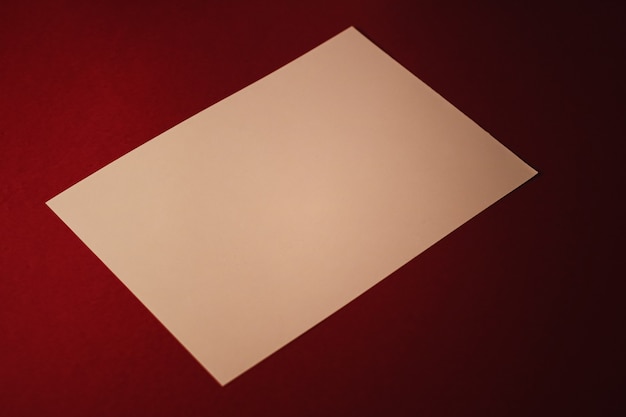 Videz un papier beige sur fond rouge foncé en tant que papeterie de bureau flatlay branding de luxe à plat et...