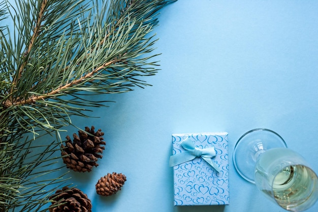 La vie encore du Nouvel An un verre de champagne Décorations de Noël et branches d'épinette sur fond bleu