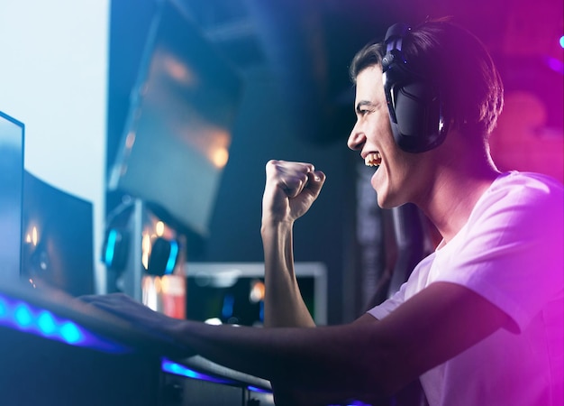 Photo la vie est un jeu, alors montez de niveau. plan d'un jeune homme qui applaudit en jouant à des jeux informatiques.