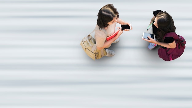 La vie humaine à distance sociale Vue aérienne de dessus avec deux étudiantes avec support pour smartphone