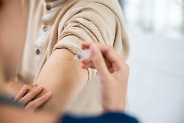 Un vieil homme âgé asiatique se fait vacciner contre le coronavirus avec une infirmière