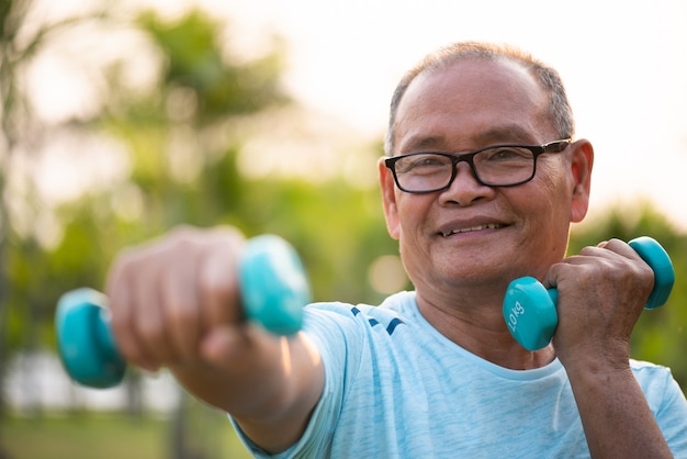 Vieil homme asiatique, faire de l'exercice physique en plein air avec des haltères