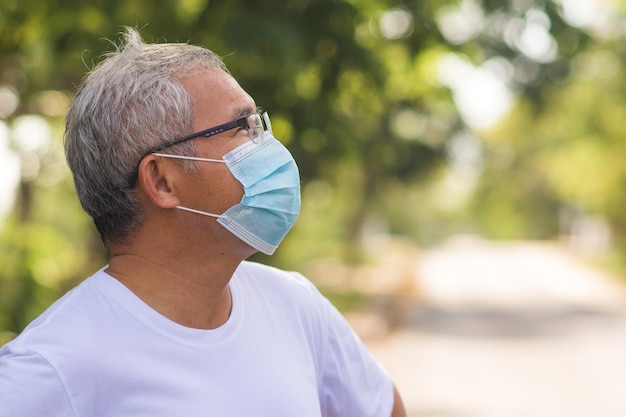 Vieil homme asiatique marchant exercice en plein air et portant un masque médical